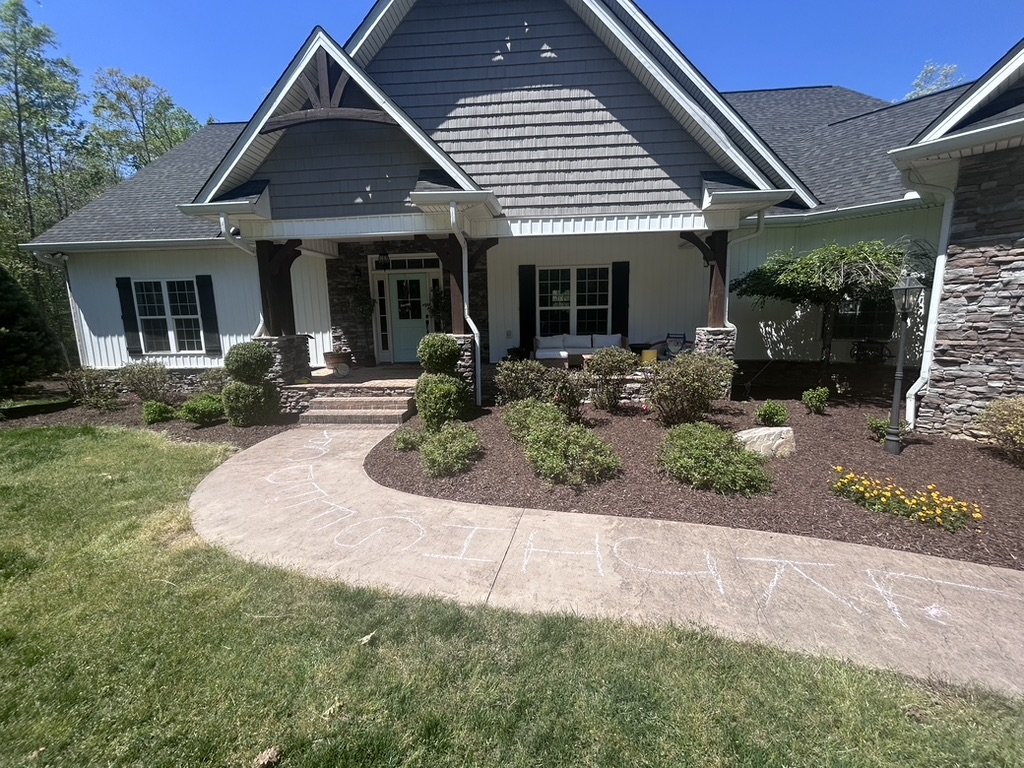 Freshly mulched garden beds and trimmed shrubs at a completed residential project